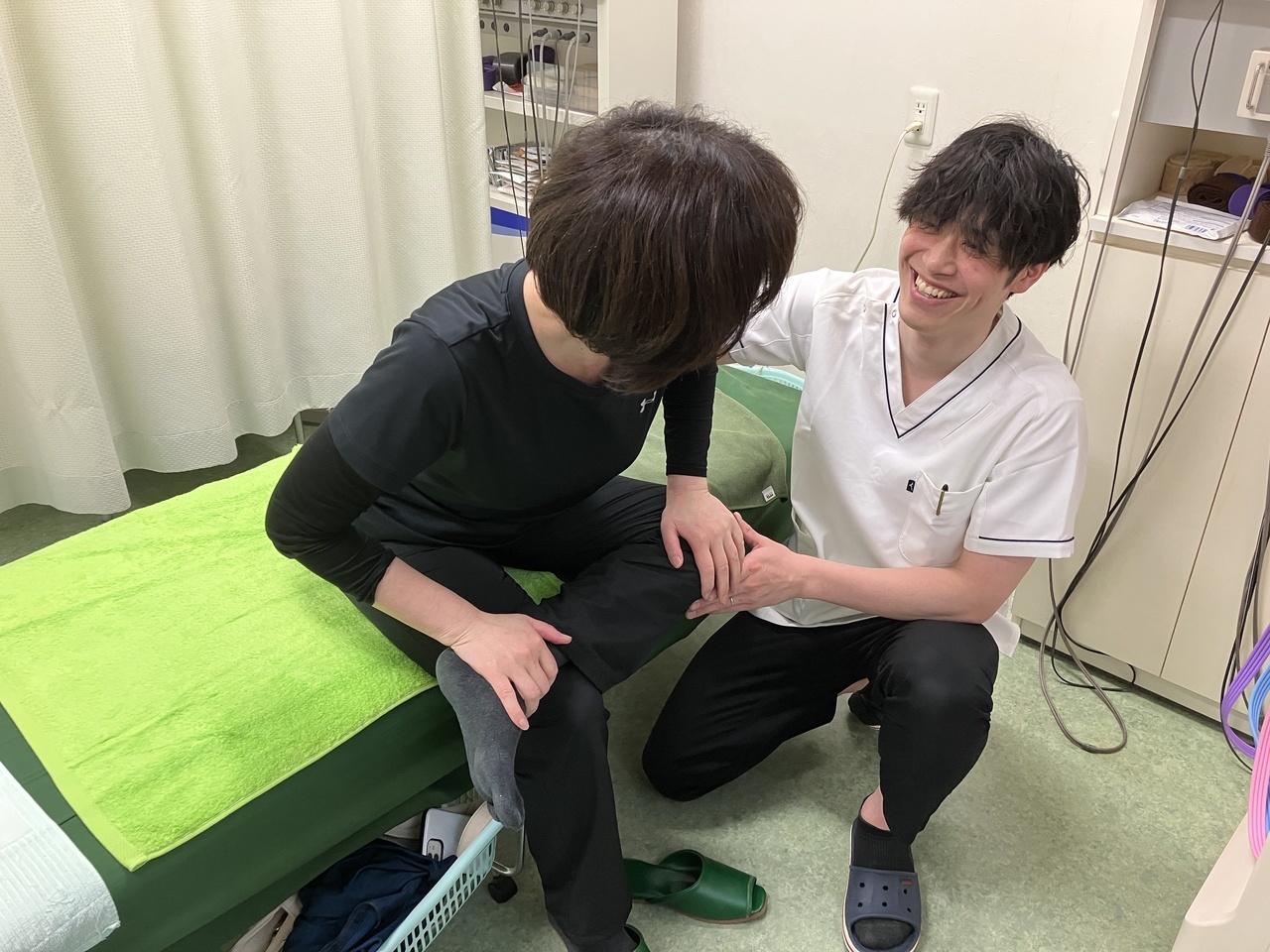 ぎっくり腰の患者さんにセルフストレッチを指導している