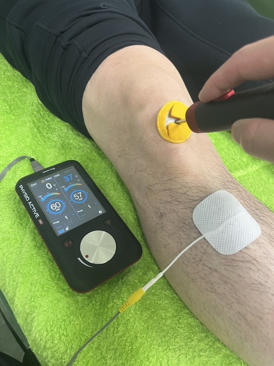 炎症が起きて痛みが引き起こっている膝関節に電気治療をしている様子